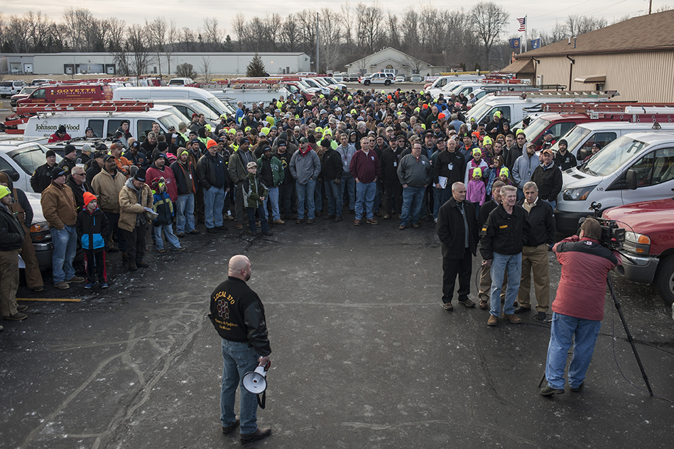 A team of volunteer plumbers assemble for a photo in a Flint, Michigan parking lot.